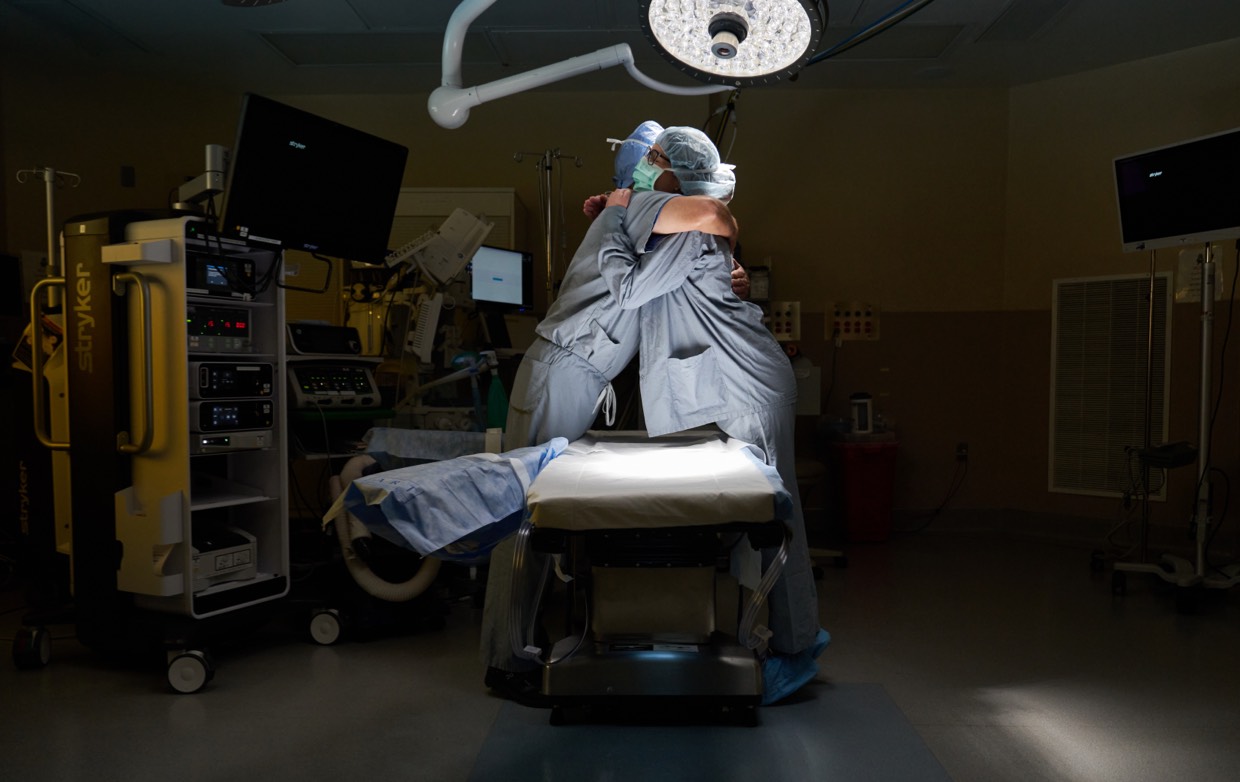 two surgeons hugging in operating room