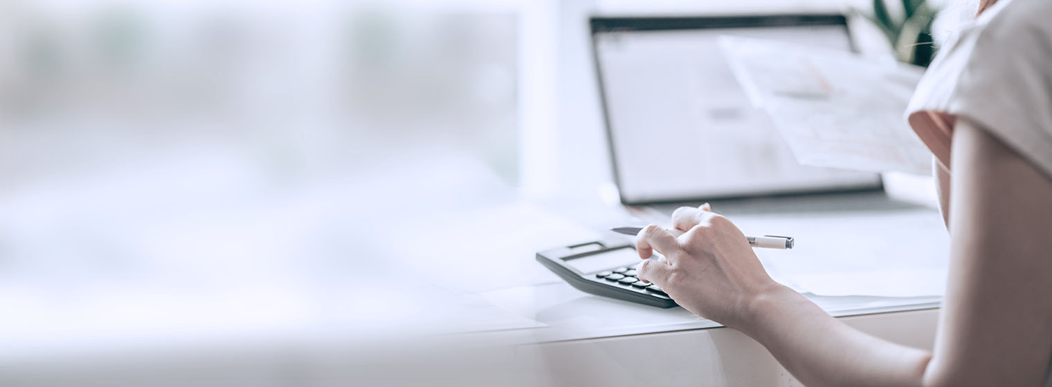 woman sitting at computer with calculator