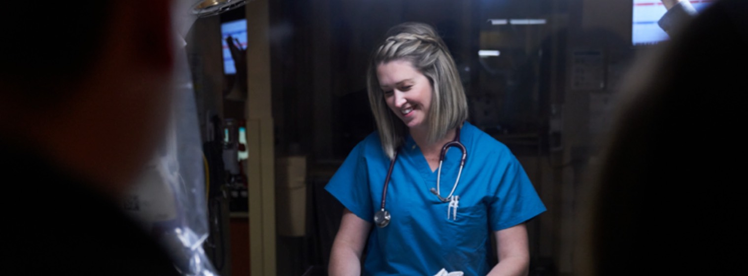 一个护士低头对着一个婴儿微笑