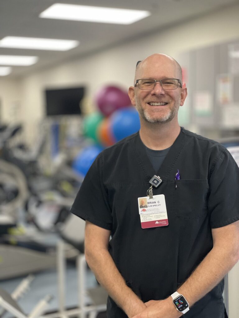 Brian Smiling in Black Scrubs in PT gym