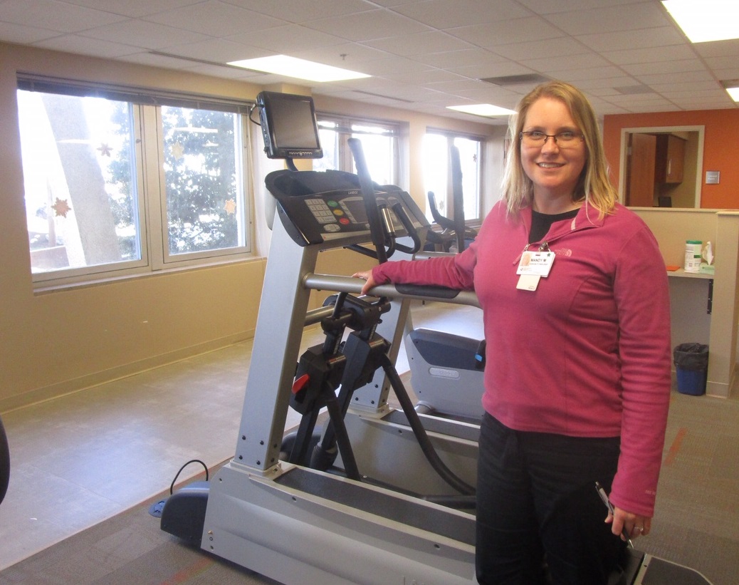 Mandy Marshall stands in front of a treadmill