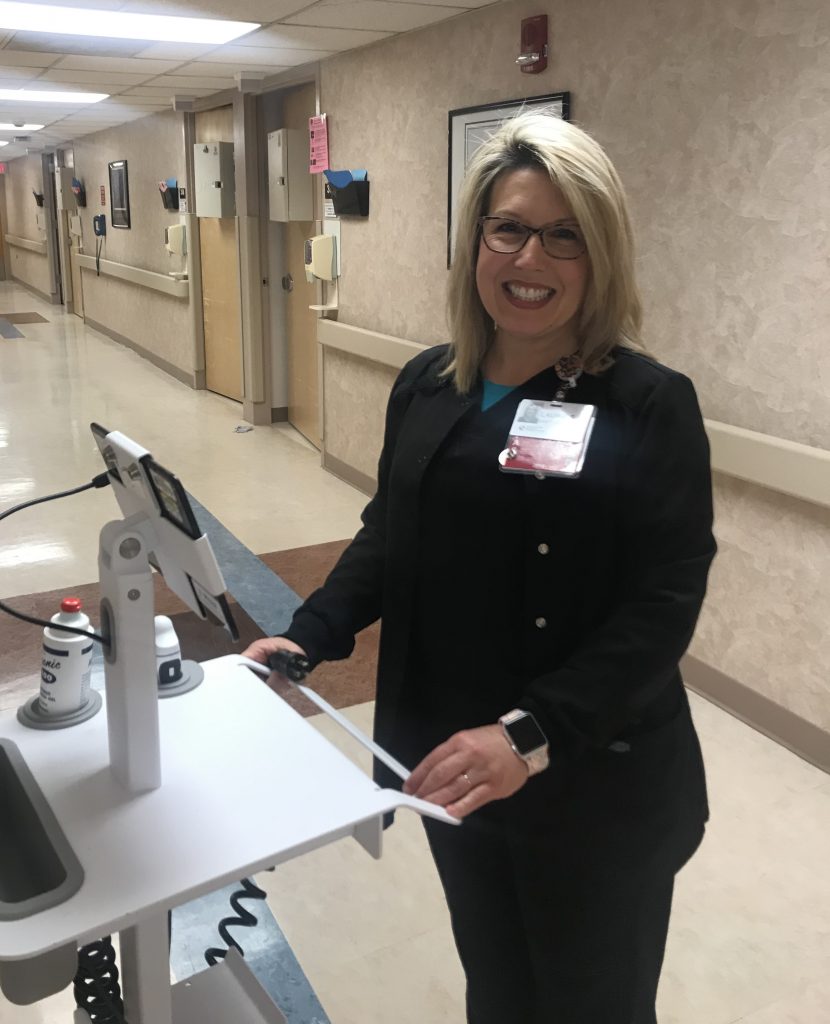 Laurie Somers stands with medical equipment in the nephorology unit