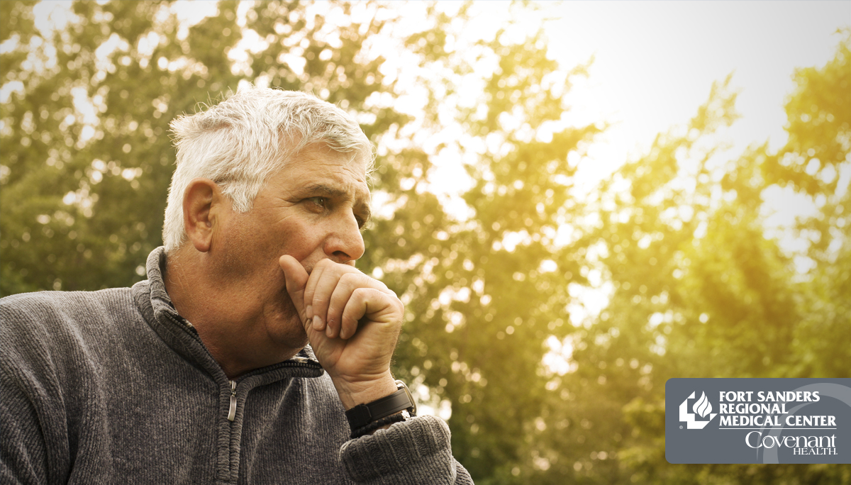 Man coughing with trees behind him due to COPD