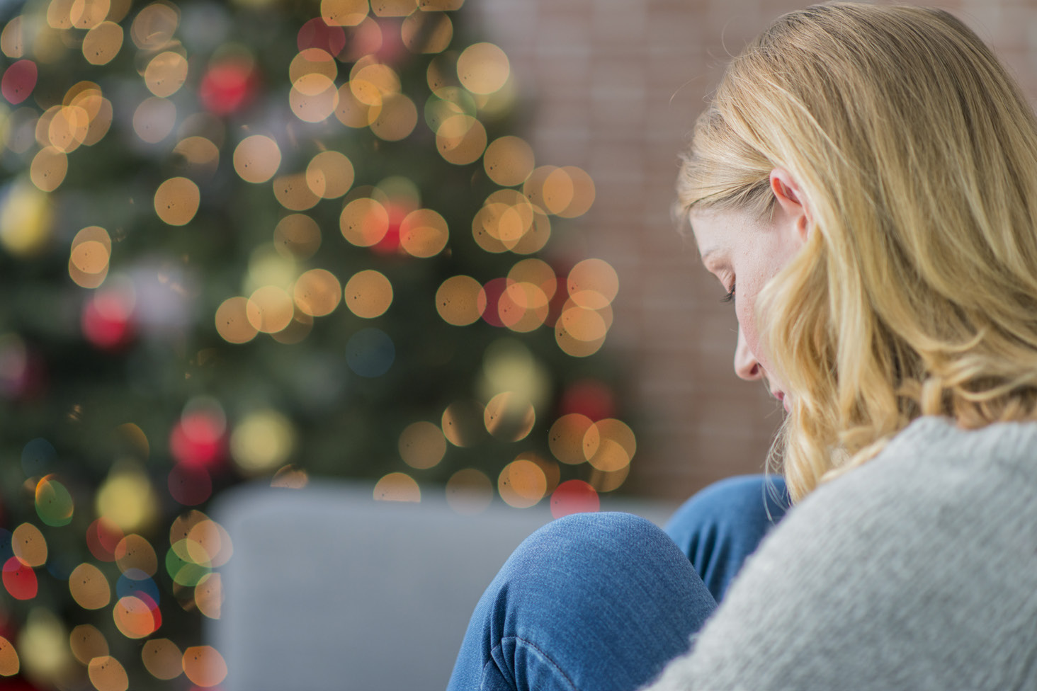 sad woman in front of a tree