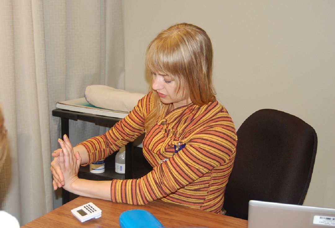 Certified hand therapist Rachel Brady demonstrates a stretch for a patient who is recovering from a wrist injury.