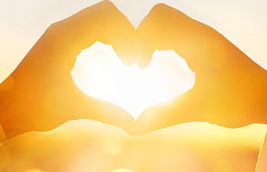 Two hands form the shape of a heart against a bright, golden sunset, with sunlight shining through—symbolizing the compassionate care found at Parkwest Medical Center. A soft, bokeh effect in the background enhances this warm and hopeful scene.