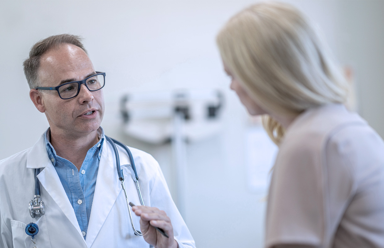 claiborne doctor talks with a patient in a room