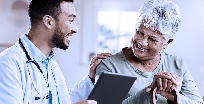 young male doctor talks to elderly woman