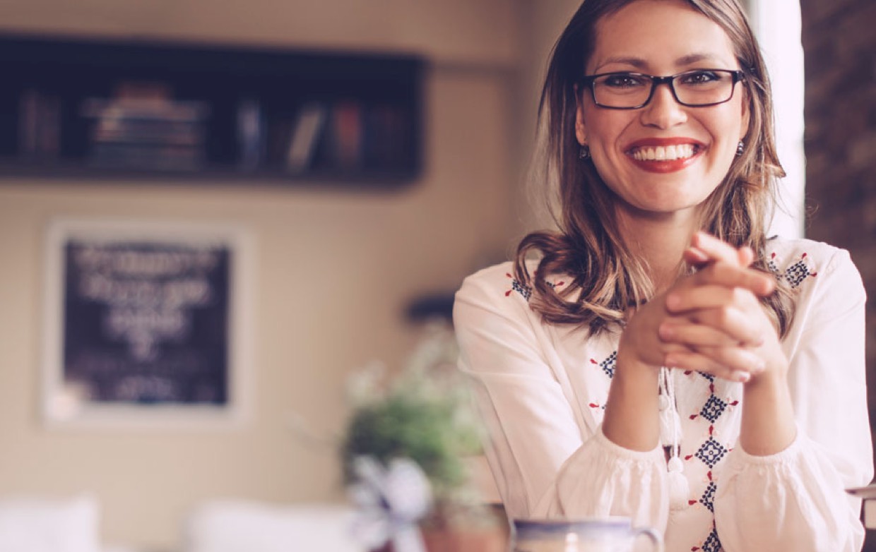 Smiling woman sitting with hands clasped