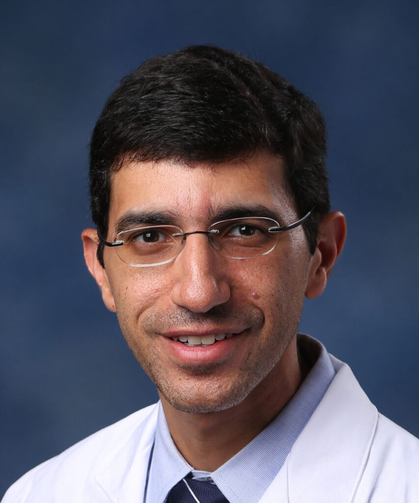 Headshot of Dr. Abdelhamid Alsharif, wearing a dress shirt, tie and white lab coat.
