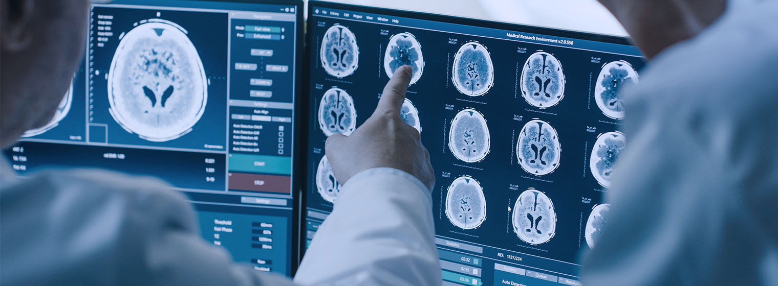 doctor points at computer monitor with mri images on the screen