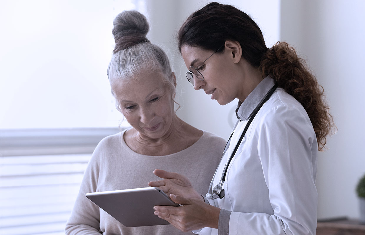 A female patient in a bun discussing care with her female doctor