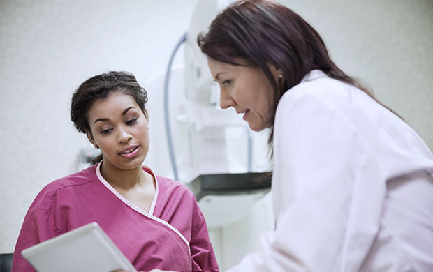 a doctor discusses a chart with a nurse