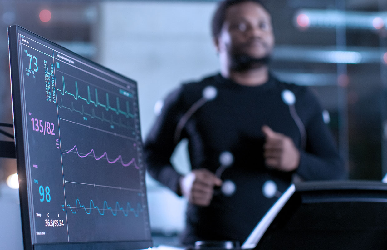 young male runs on treadmill with heart monitors