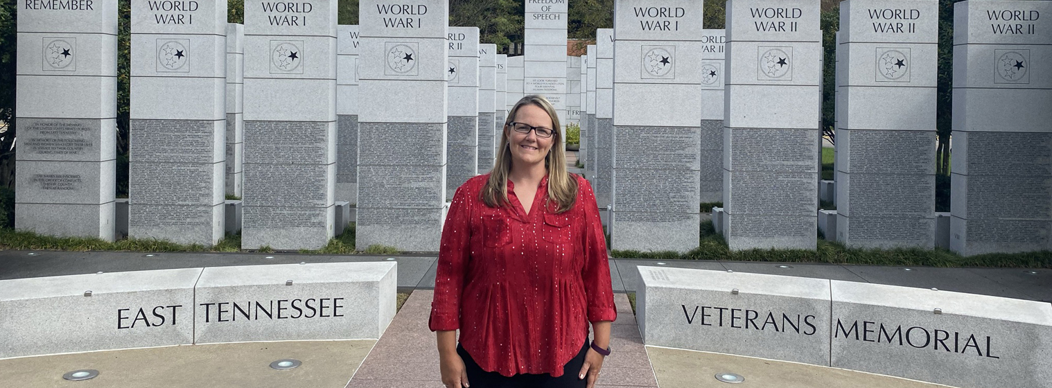 Cindy Winterberger stands in front of veteran memorial