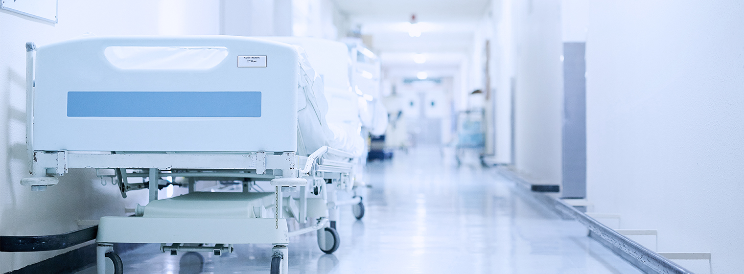 hospital bed in hallway with fluorescent lighting