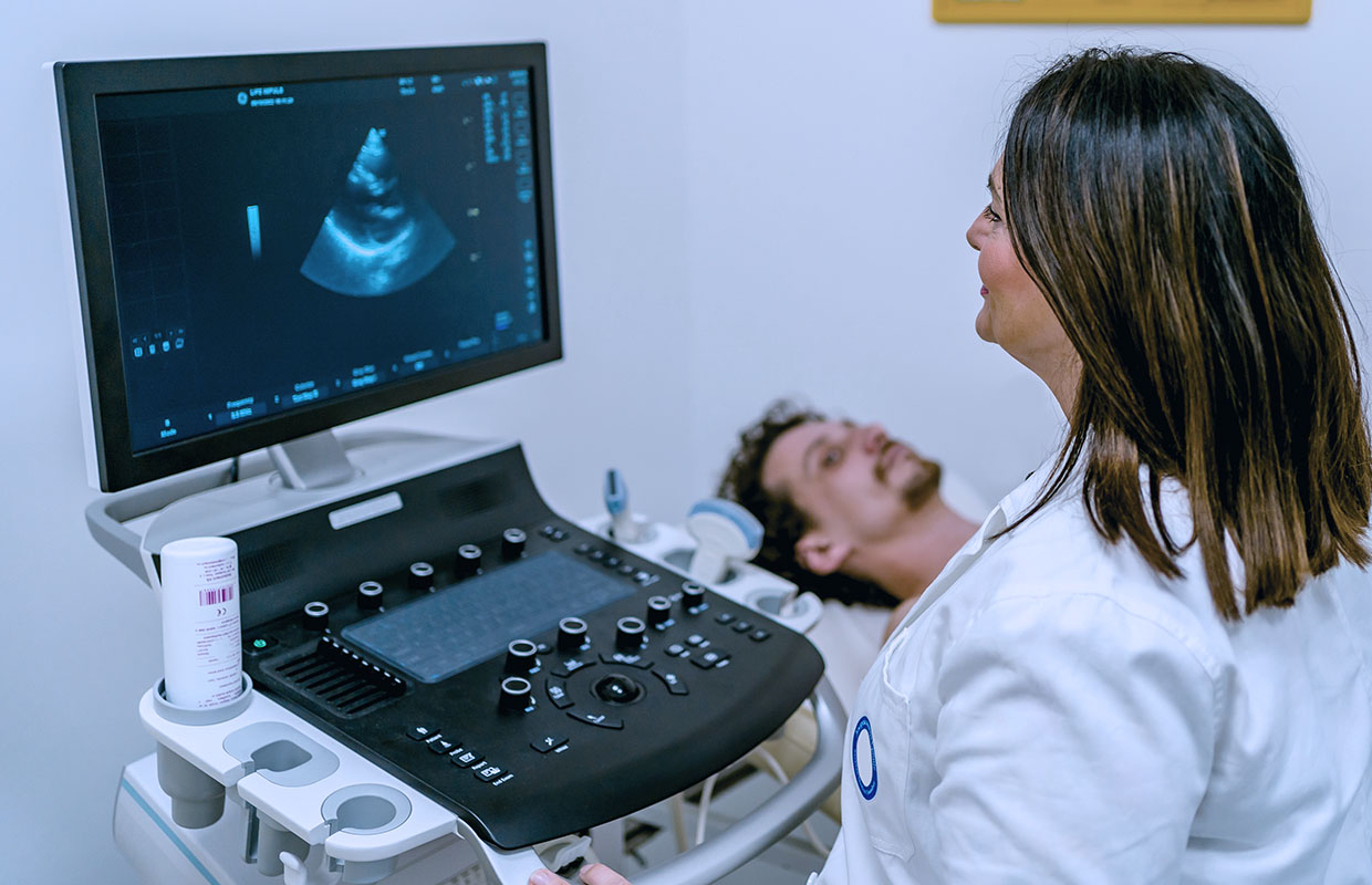 young female doctor takes ultrasound of male patients heart