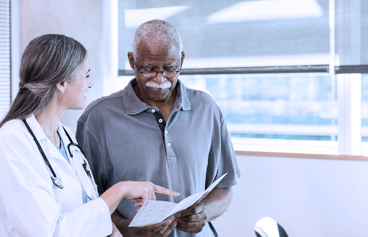 A female doctor explaining a sheet of instructions to a male patient