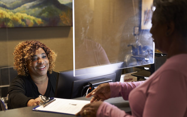 Covenant Health staff handing patient forms to be completed