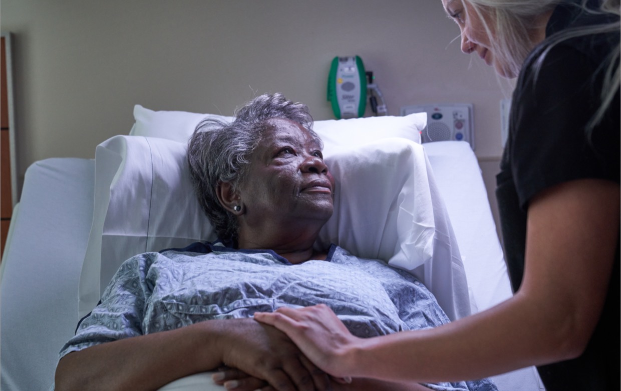 A nurse checking on an elderly female patient