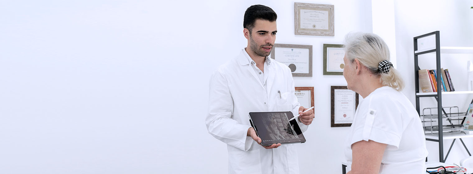 young male doctor showing xray to senior female patient