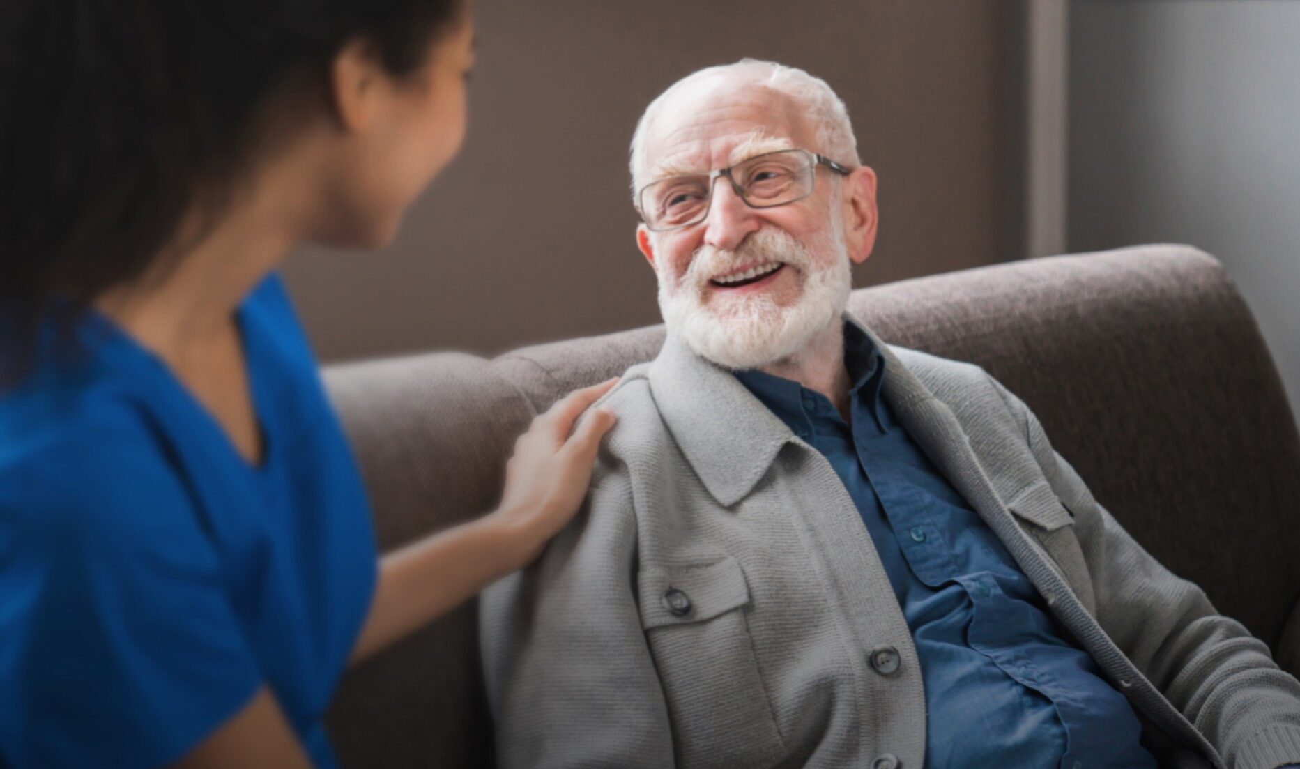 behavioral health nurse in blue scrubs with her hand on older man's shoulder