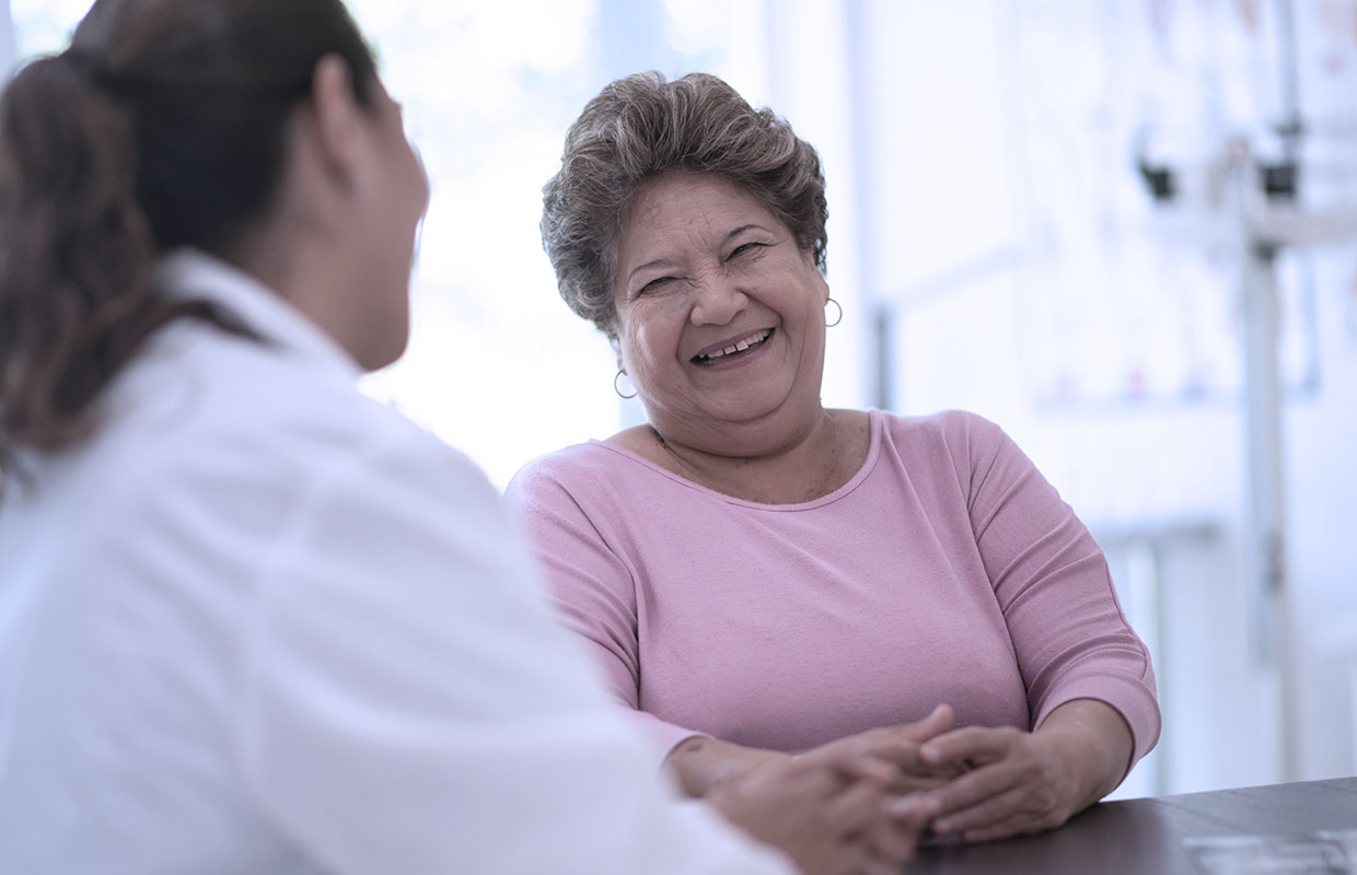 female doctor talks to female patient in exam room