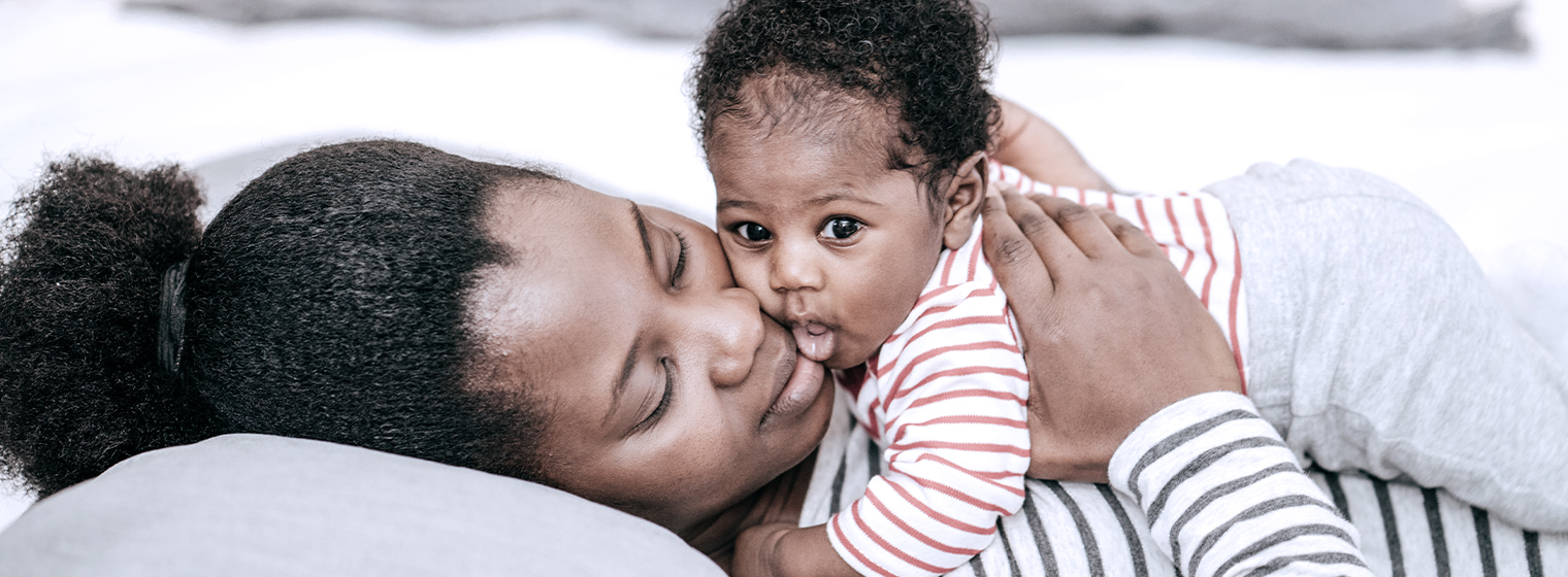 mom holding baby while laying down