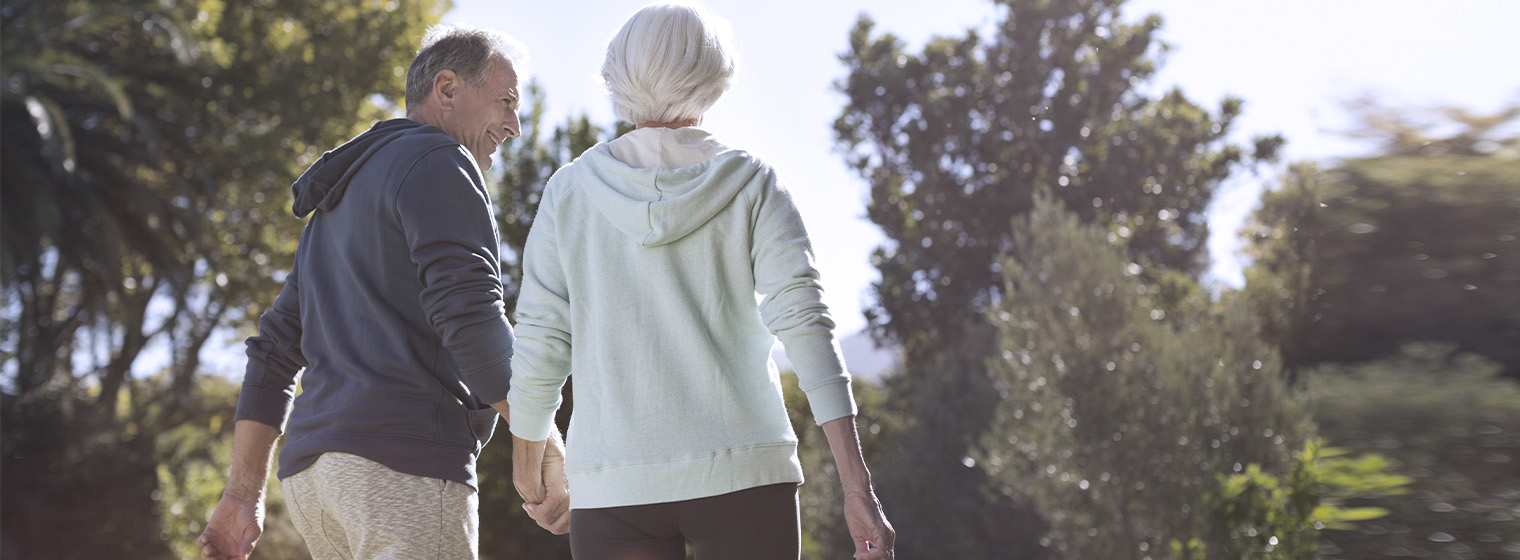 senior couple walking through the woods