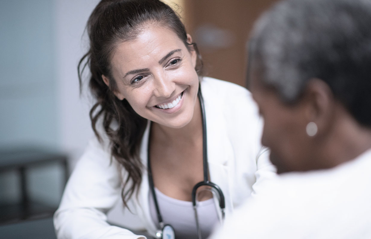 young female doctor smiling at older woman