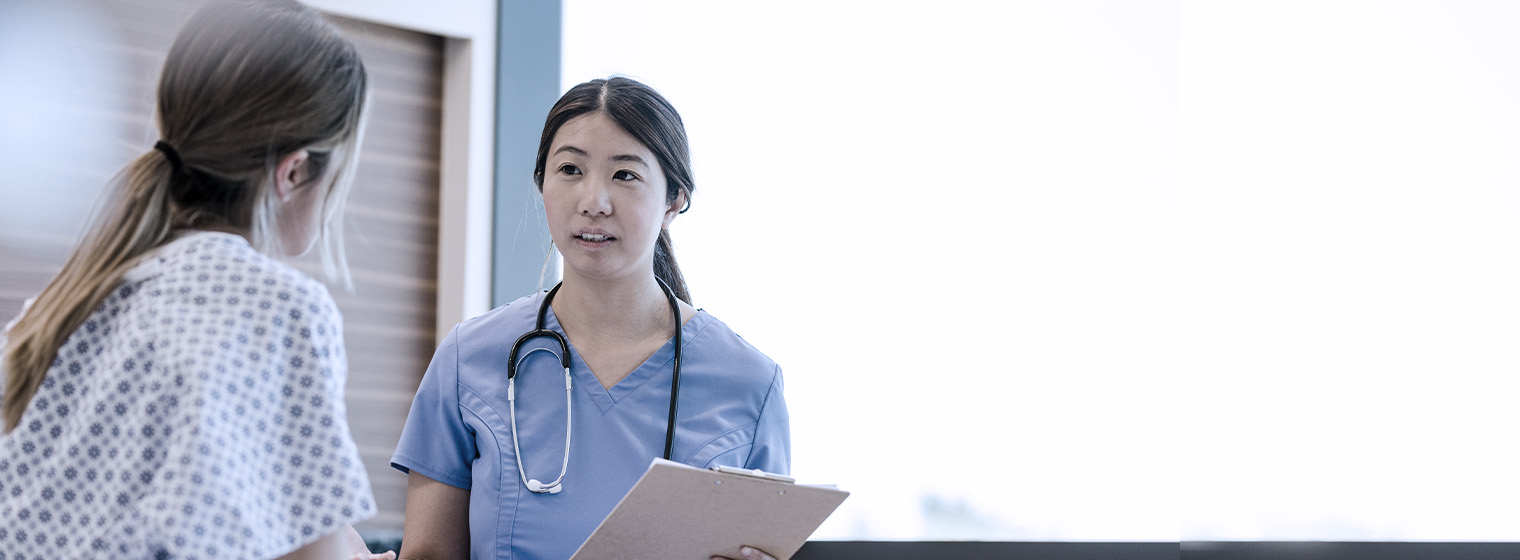 patient talks to nurse in blue scrubs