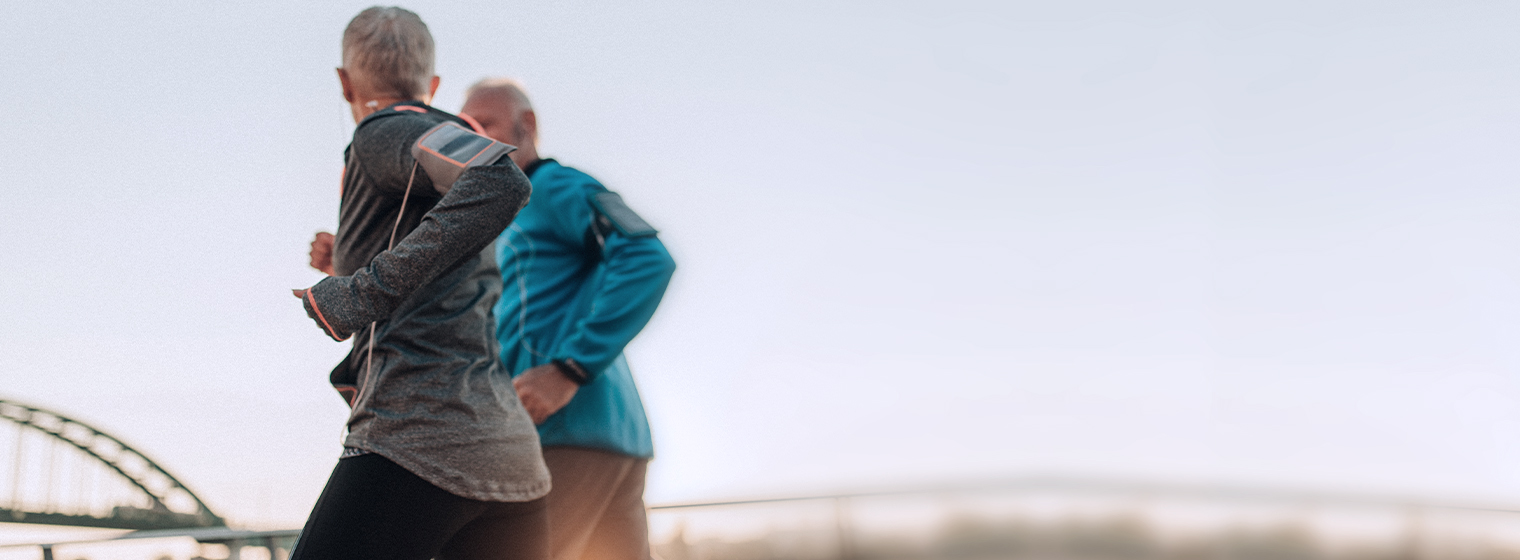 Couple runs together outside.