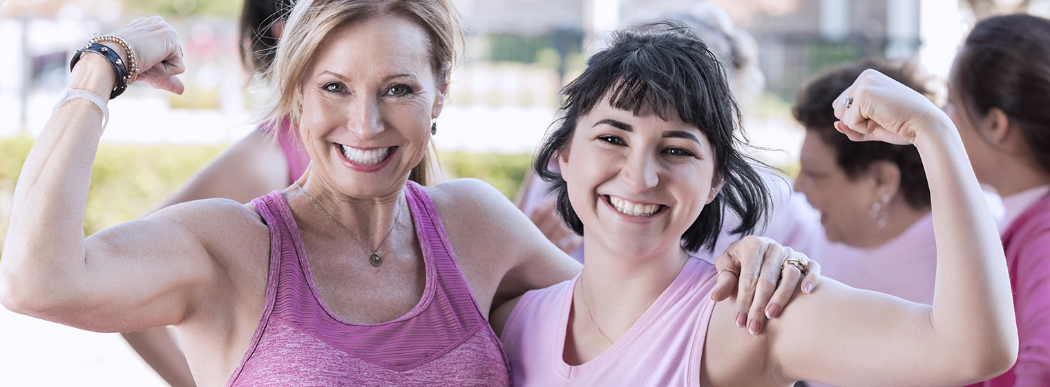 two females in pink showing off their biceps