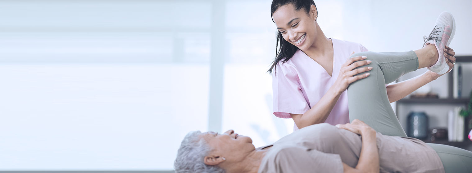 female physical therapist helping elderly patient