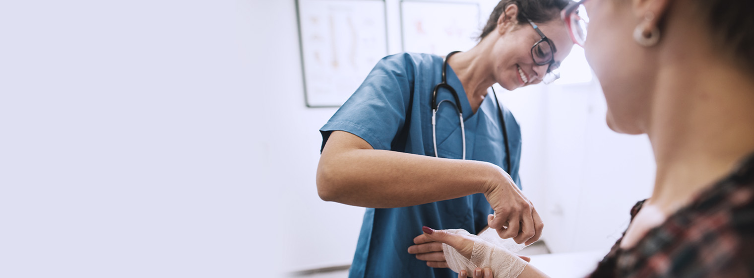 young female nurse wrapping a patient's wrist