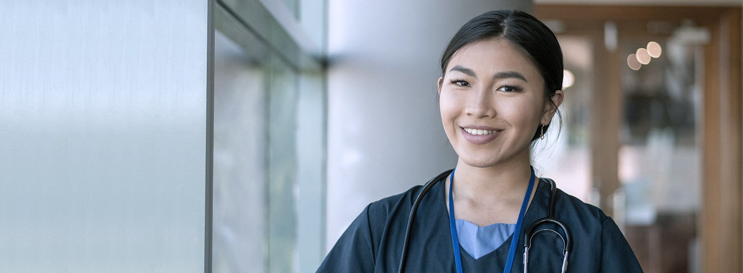 young female nursing student in scrubs smiling at camera