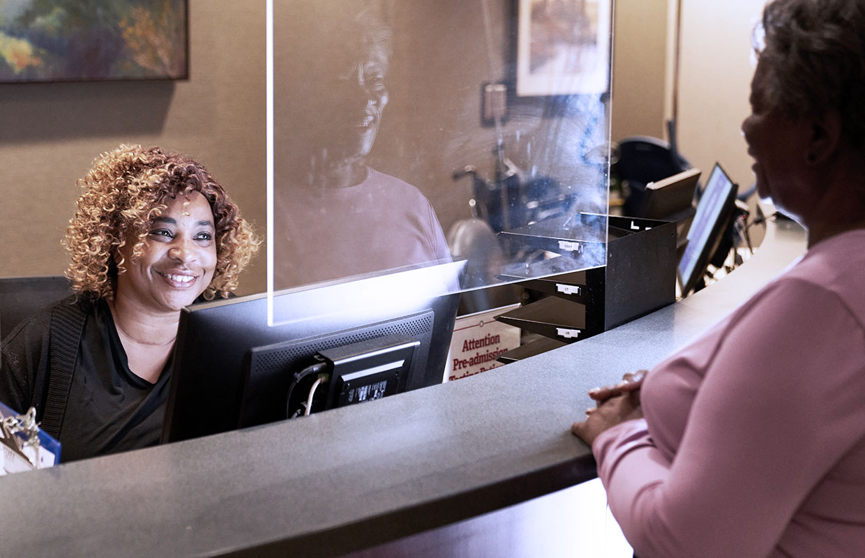 female checking in female patient at registration desk