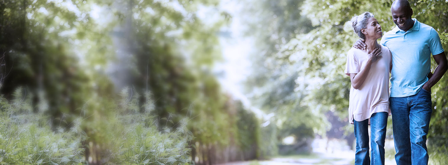 older couple walking on a path through the woods