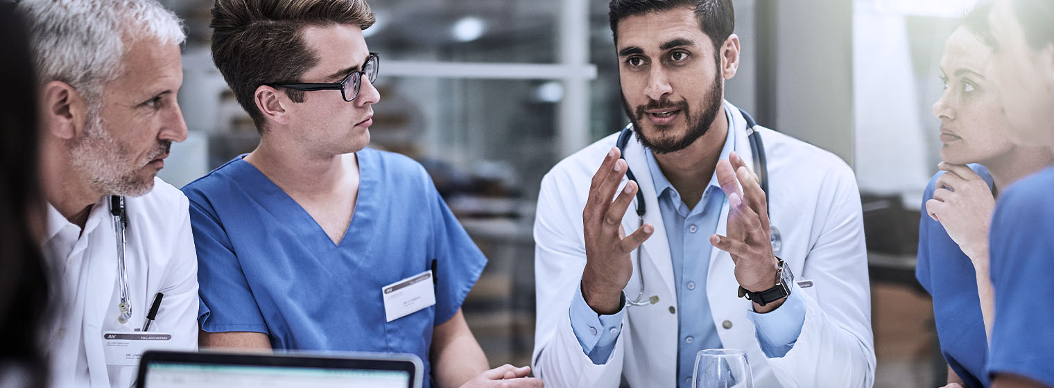 group of nurses and doctors having a discussion at a table