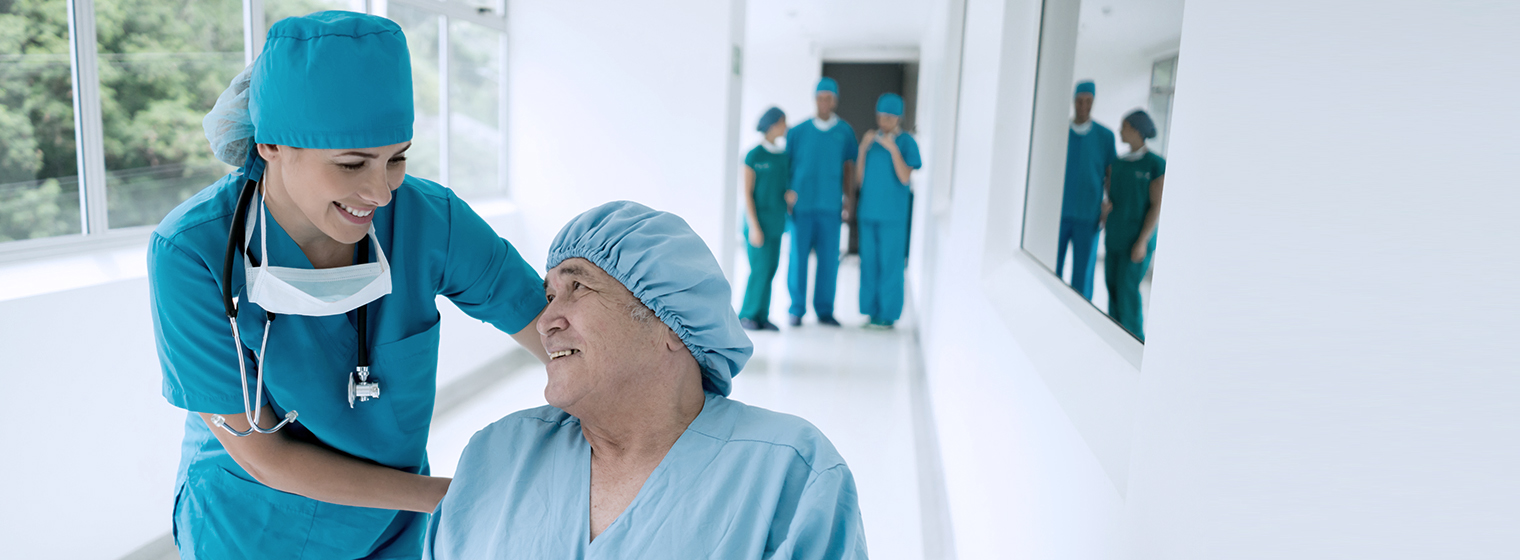 female surgeon in scrubs walking down a hallway with a male patient in scrubs