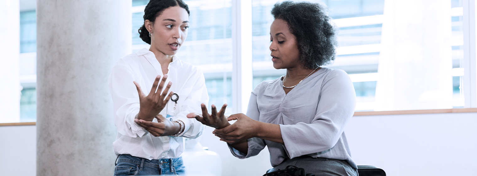 Physical therapist evaluates a patient's range of motion while participating in certified hand therapy.