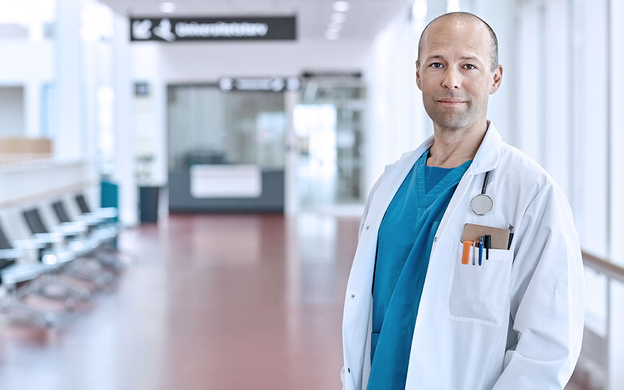 male doctor standing in hallway posing