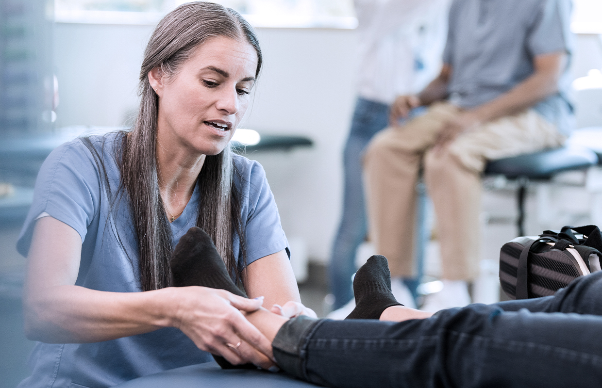Physical therapist performs evaluation of a patient's ankle.