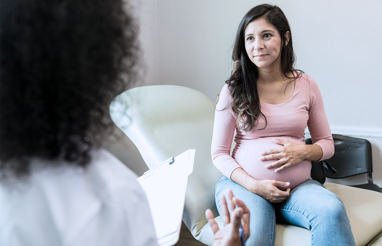 Pregnant mother speaks with her OB/GYN about maternity services.