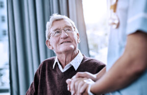 elderly male looking up at a nurse