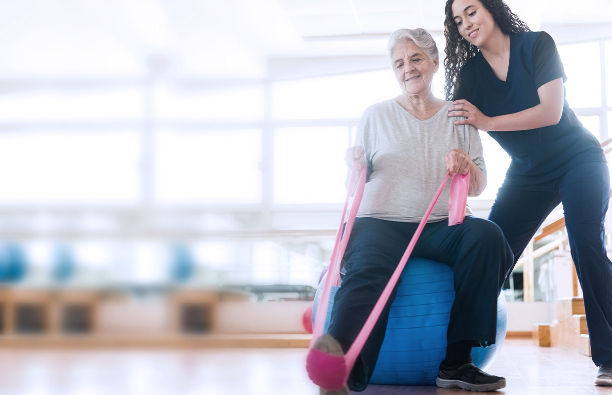 Female physical therapist helps senior with Parkinson's Disease complete LSVT therapy.