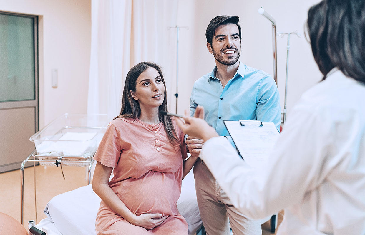 Young couple discusses maternity services at Covenant Health with their OB/GYN.