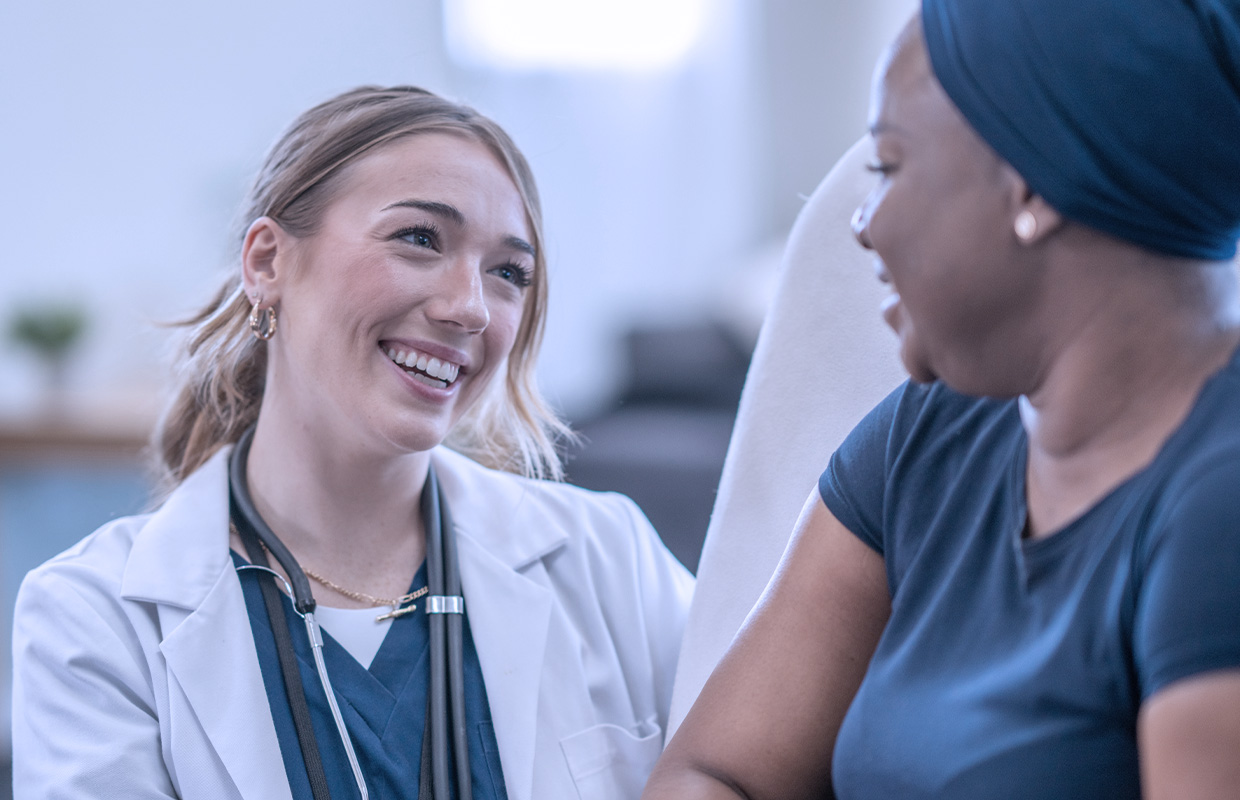 young female doctor smiling at cancer patient