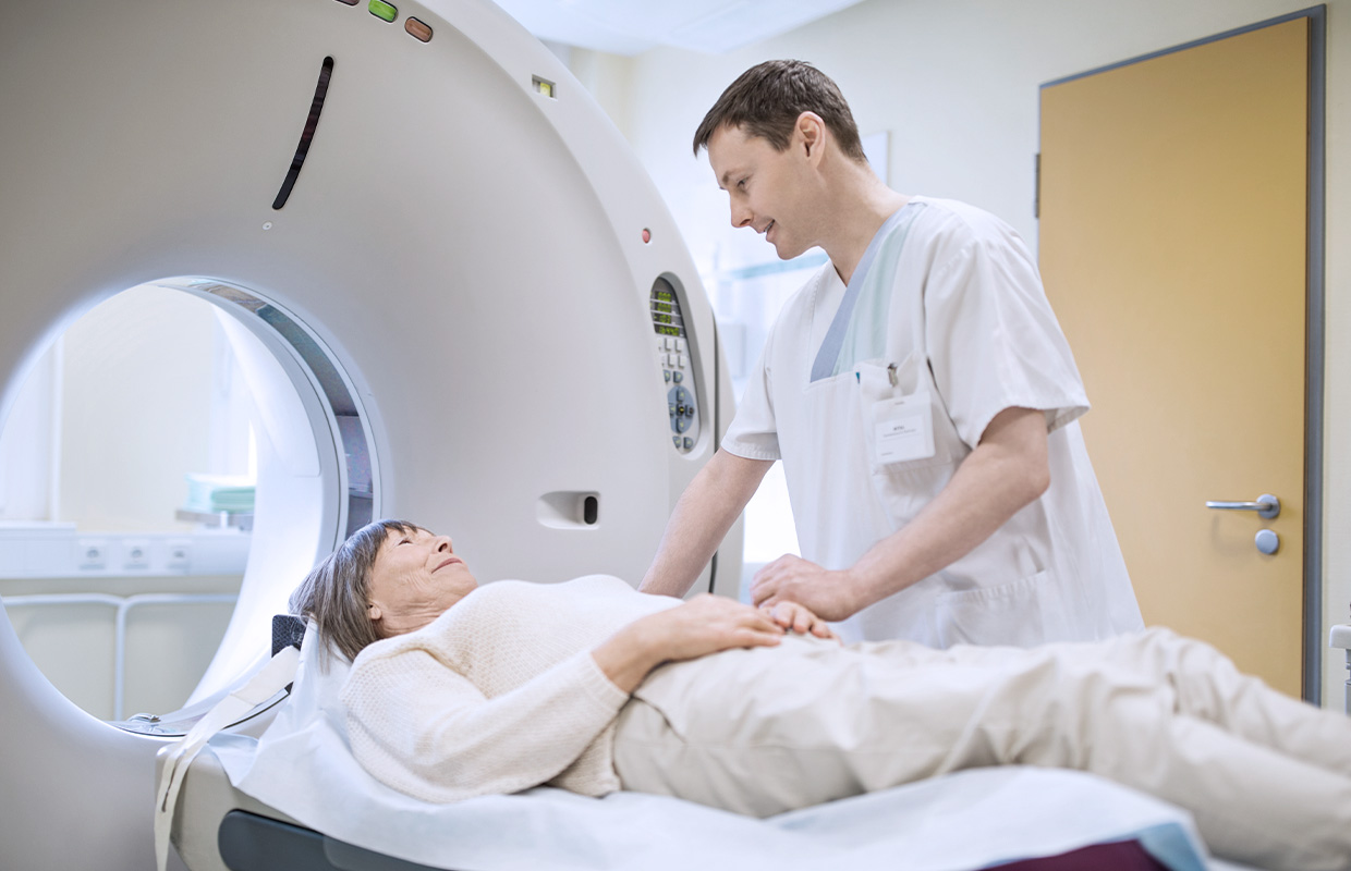 male radiologist talking to a patient before her CT scan