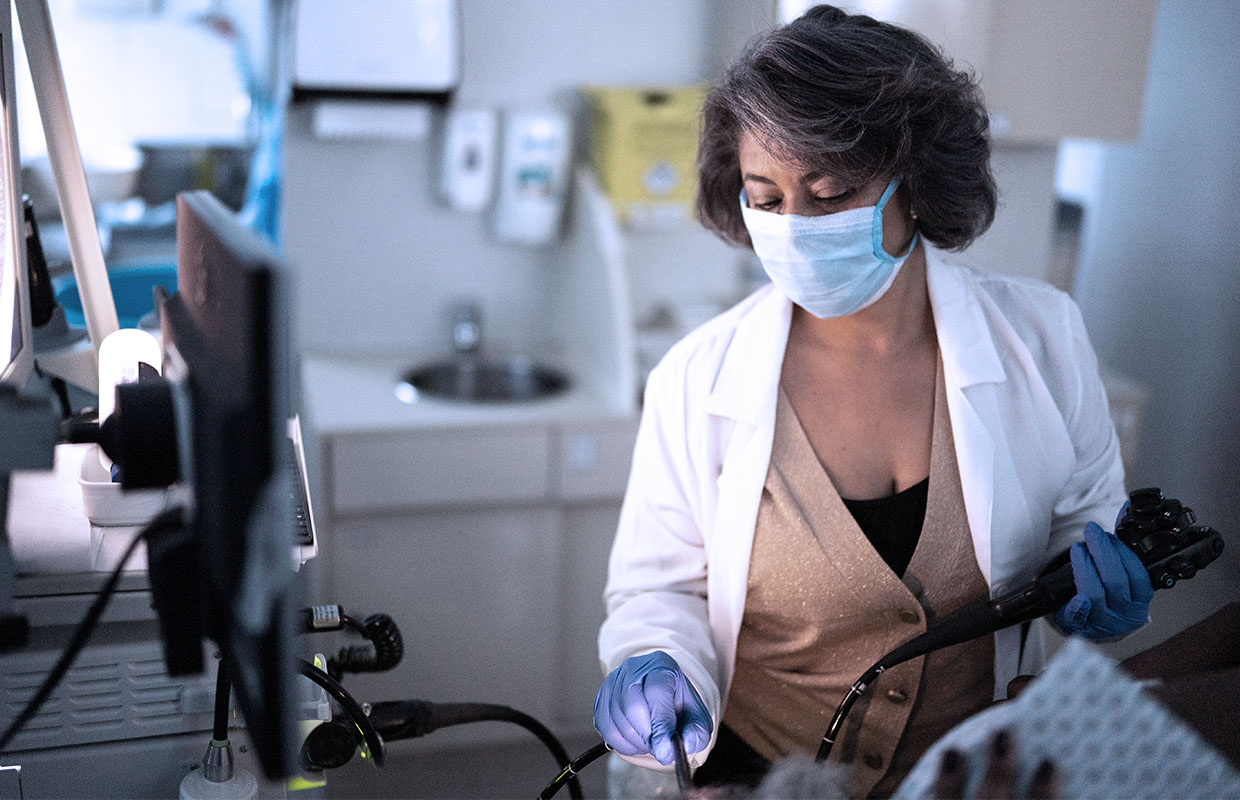 a doctor performs a procedure on a patient while holding a medical device